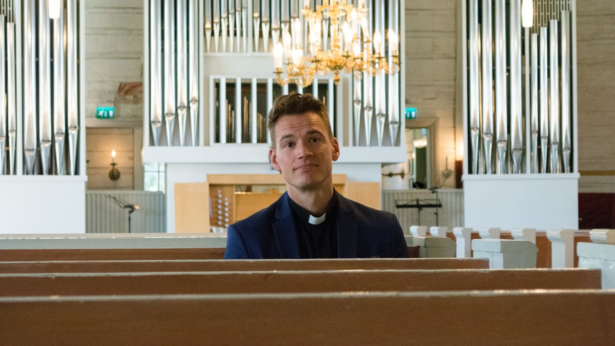 Haukiputaan seurakunnan kirkkoherra Jaakko Tuisku istuu kirkon penkissä