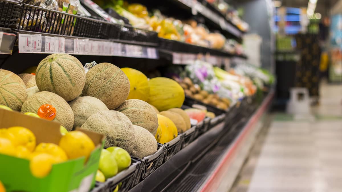 Kuva kaupan hedelmäosastolta. Etualalla on cantaloupe-meloneja