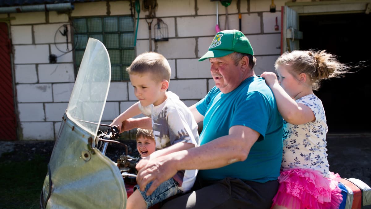 Marju Vesikin isä Arvo Vesik ajeluttaa lapsenlapsiaan perinteisellä kihnulaisella kulkuvälineellä: sivuvaunullisella moottoripyörällä.