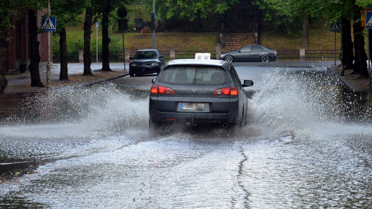 Auto ajaa tulvivalla kadulla Riihimäellä.