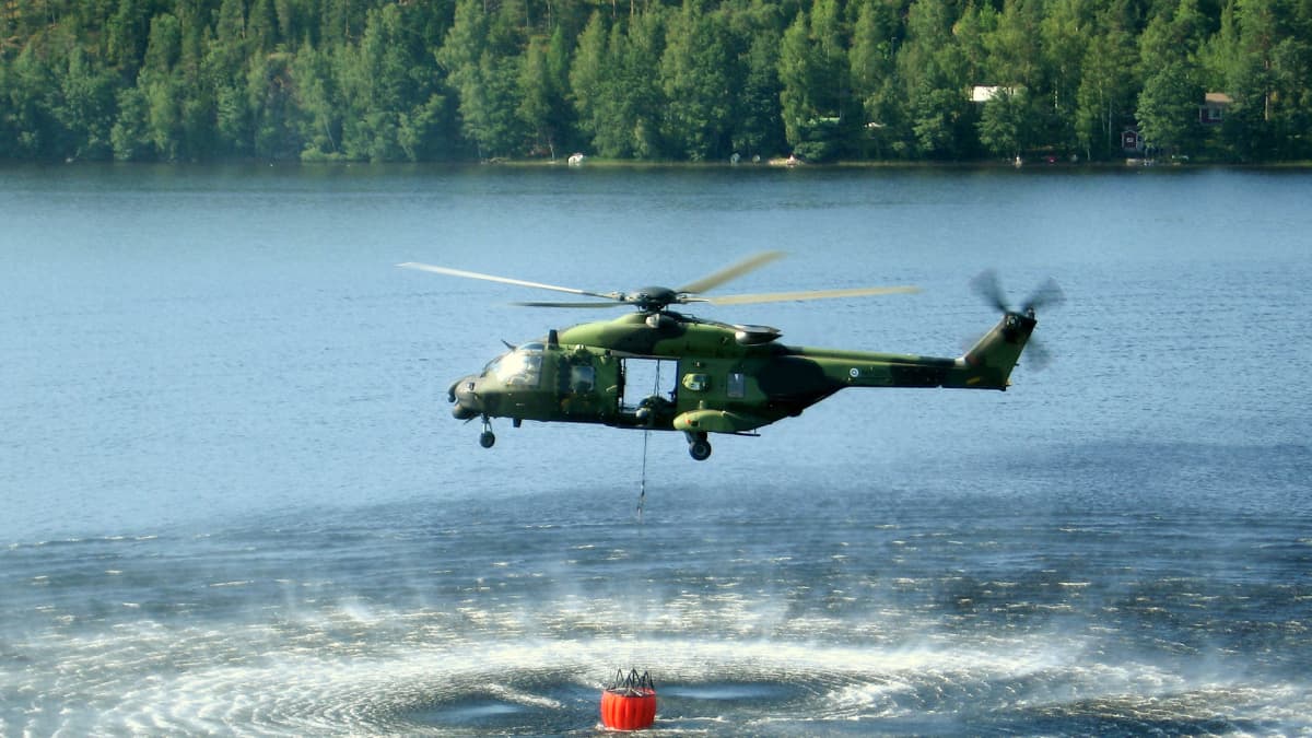 Puolustusvoimien NH90 -kopteri täyttämässä vesisäiliötä.