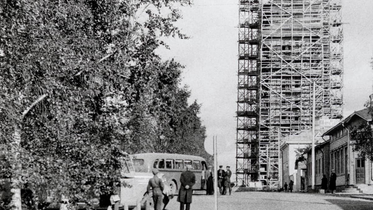 Kemin kaupungintalo harjannostajaispäivänä 23.9.1939. Kuva otettu Iso-Puistokatua (nyk. Meripuistokatu) itään päin. Rakennustyöt olivat vielä kesken. Kaupungintalo on kokonaan rakennustelineiden peitossa. Vasemmalla puolella näkyy linja-autoja Osuuskaupan aukealla. Kuvaaja: Väinö Pekkala.