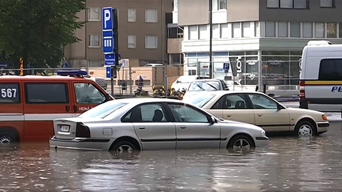 Autoja juuttuneena kaduille tulvineeseen sadeveteen