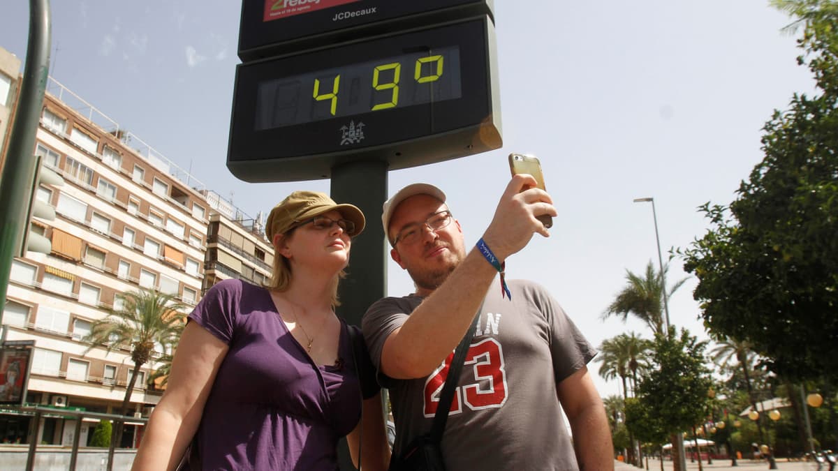 Turistit ottivat selfien lämpömittarin edessä Cordobassa, Espanjassa 1. elokuuta.