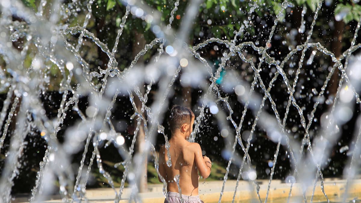 Poika vilvoitteli suihkulähteessä Rio-puistossa Madridissa 1. elokuuta.