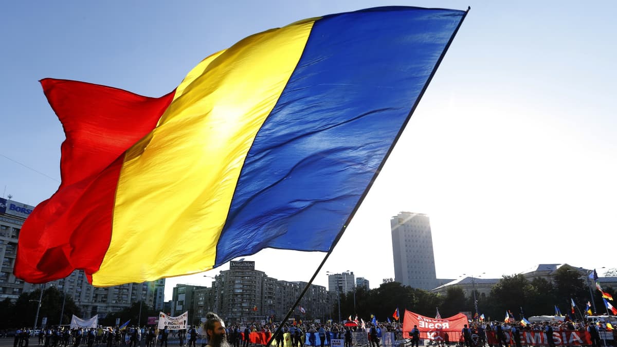 Mielenosoitukset jatkuvat Romaniassa. Ihmiset kantavat Romanian lippuja ja tekstilakanoita.