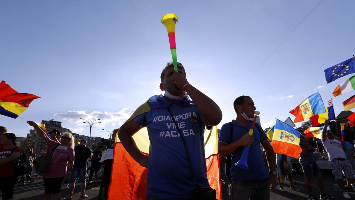 Mielenosoittajilla on mukana Romanian ja EU:n lippuja, muovisia torvia ja tekstilakanoita.