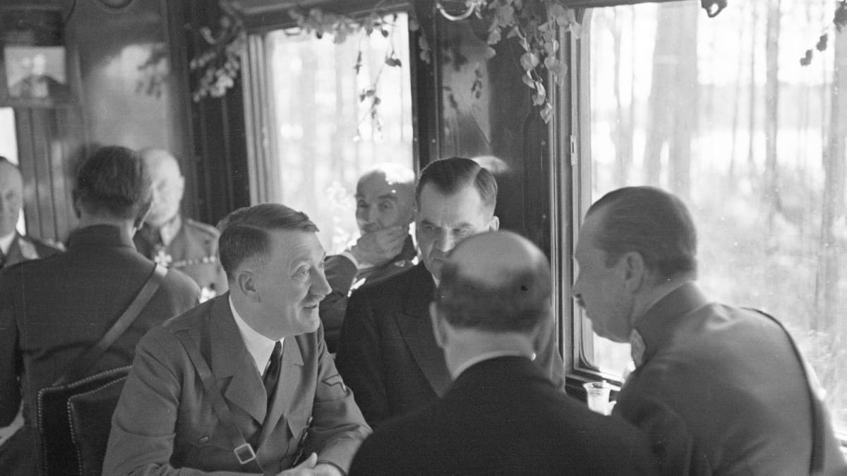 Pöydän ääressä valtakunnankansleri Adolf Hitler, pääministeri Jukka Rangell, tasavallan presidentti Risto Ryti ja marsalkka Mannerheim.