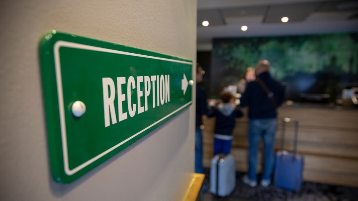 Kuva hotellivastaanoton vihreästä kyltistä, jossa lukee reception.