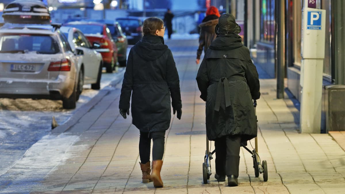 Nuori ja vanha nainen kävelevät kadulla.