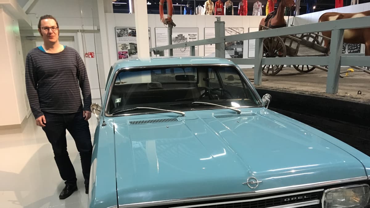 Mies seisoo automuseo Mobiliassa 1970-luvun Opelin vieressä.