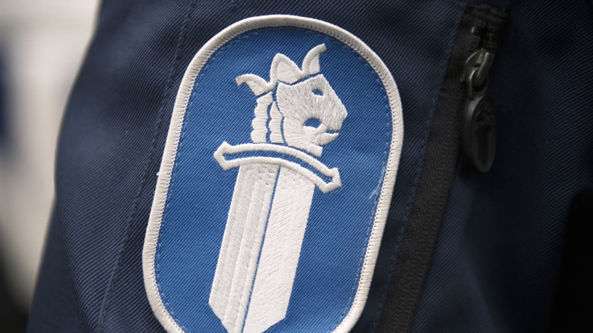 Poliisiin logo poliisi univormussa