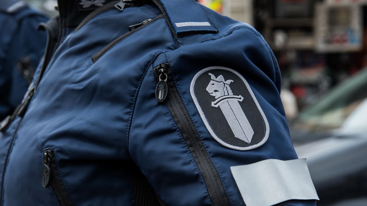 Poliisiin logo poliisi univormussa
