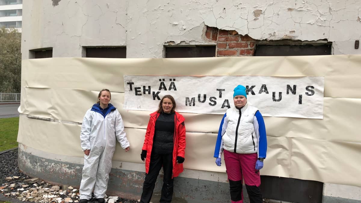 Suojellun funkkishuoltamon seinille maalataan kantaa ottavaa katutaidetta. Kuvassa ovat opiskelijat Teea Viherkari, Maria Talvensaari ja Johanna Piirainen.
