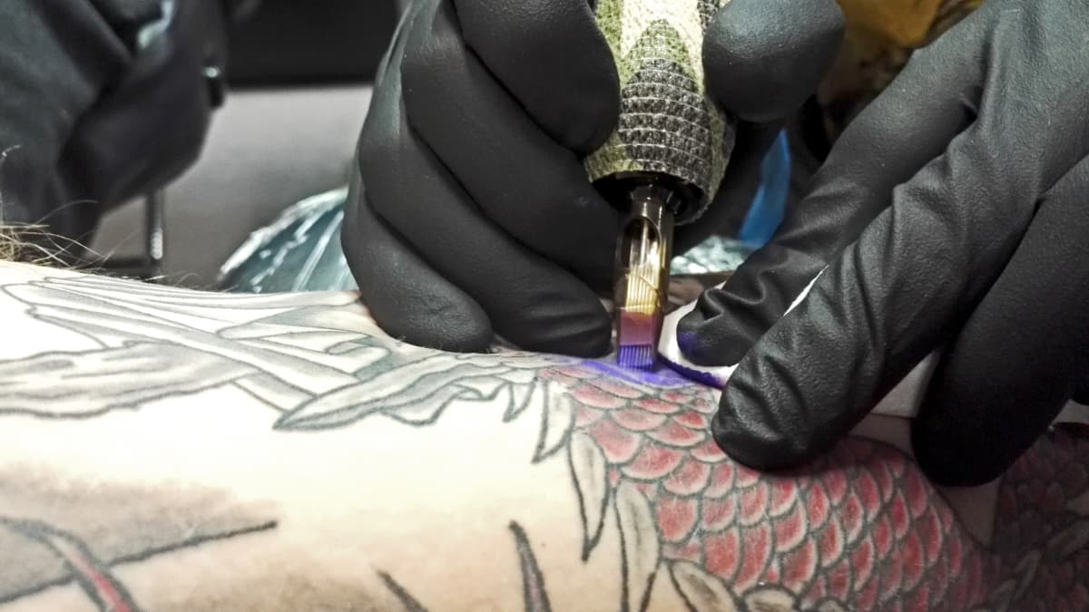 Porilainen tatuointiartisti Tuoppi Latvala tekee tatuointia asiakkaalle. (kuvituskuva)