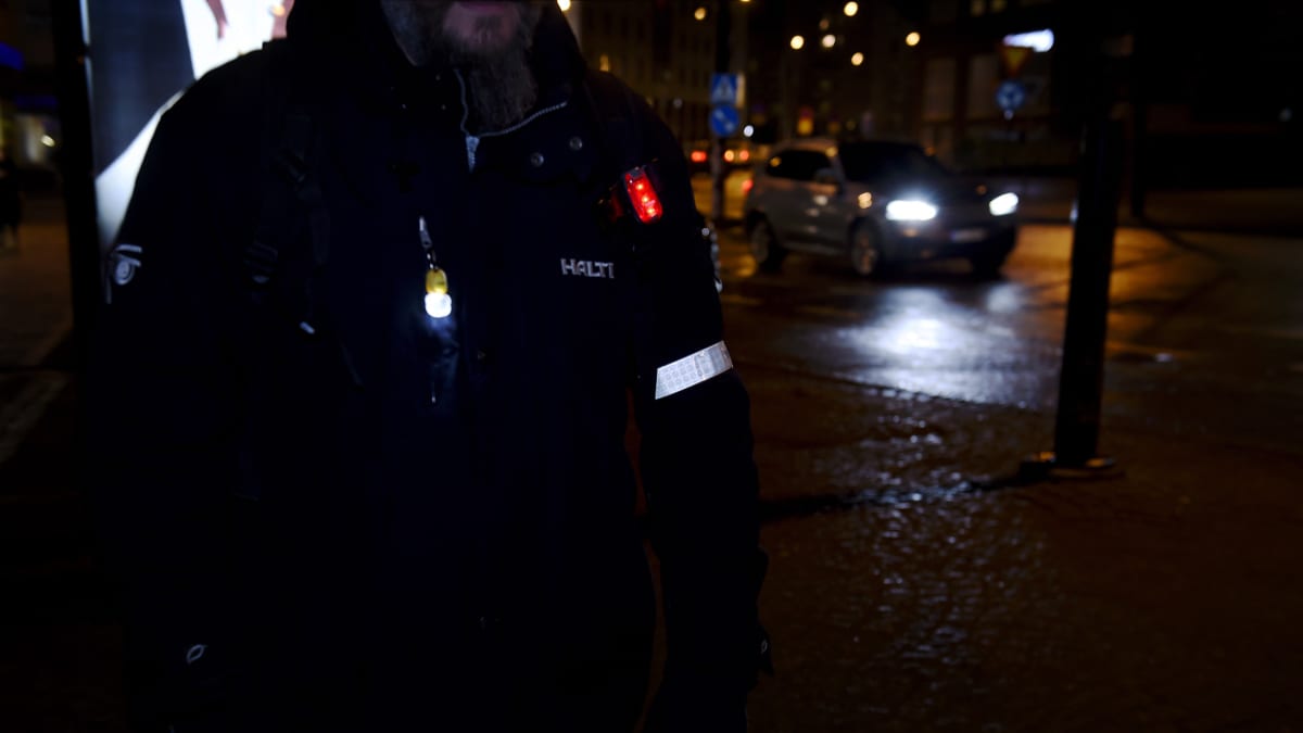 Heijastin ja led-valoja jalankulkijalla.