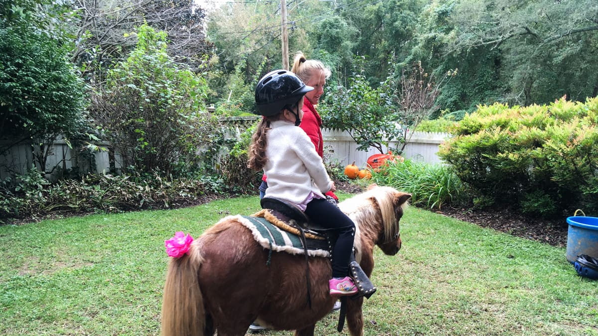 Lapsi ratsastaa ponilla.