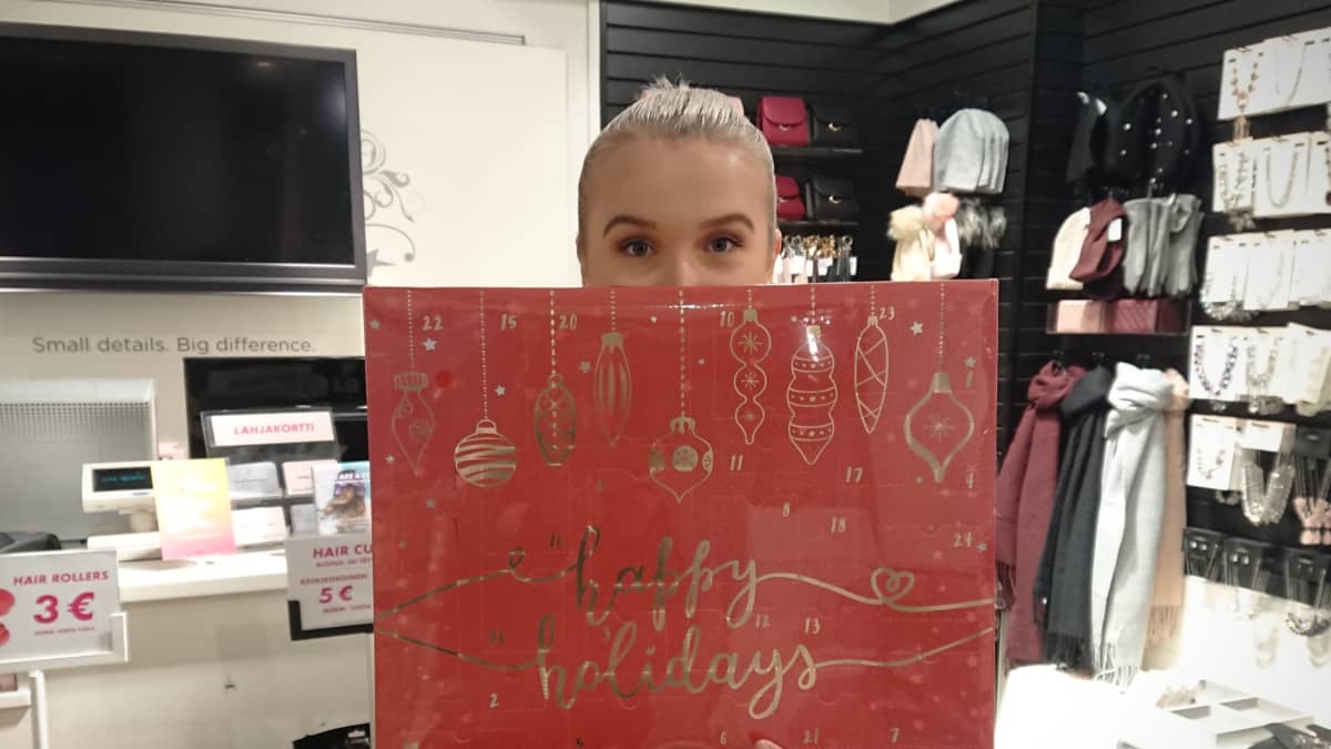 Heidi Malinen pitelee käsissään joulukalenteria Glitterin Joensuun myymälässä.