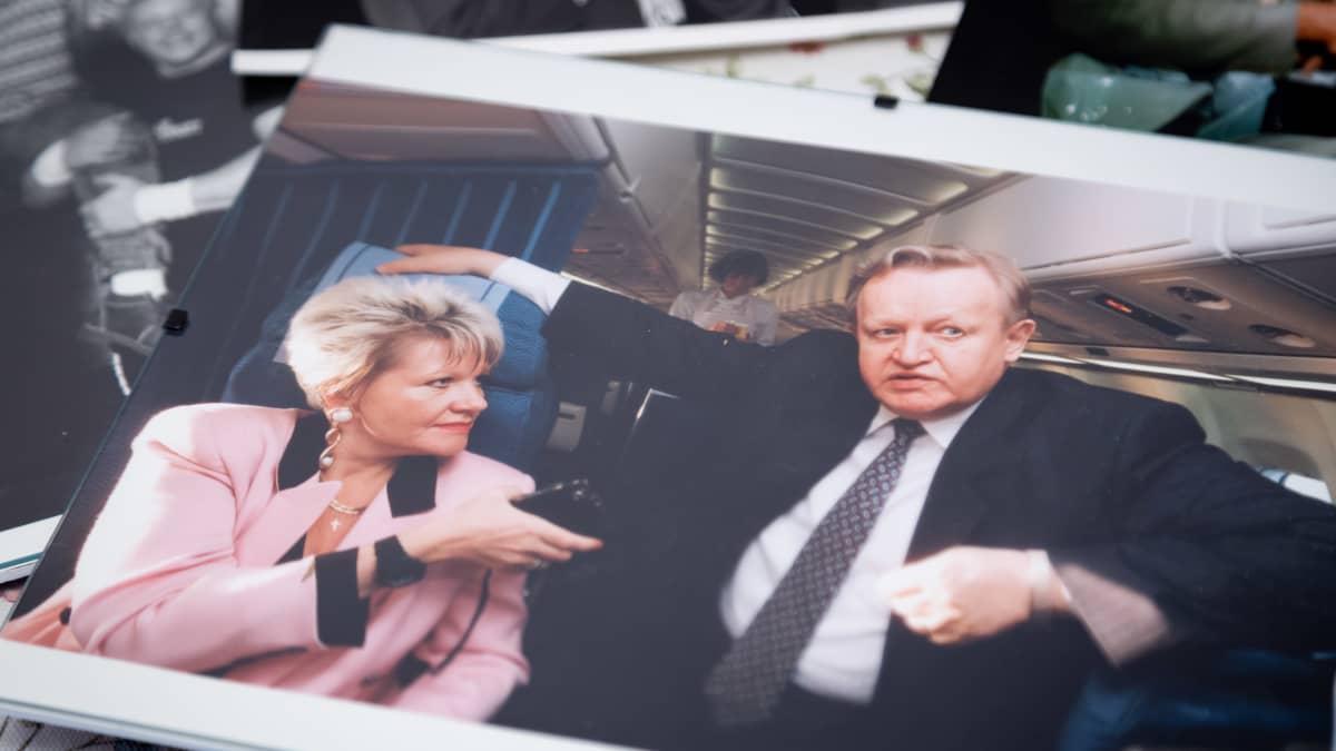 Valokuvassa toimittaja haastattelee presidentti Ahtisaarta lentokoneessa.