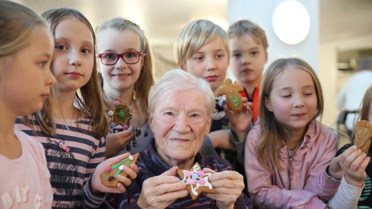 88-vuotias Martta Kuuva ja iltapäiväkerhon lapset koristelivat yhdessä pipareita.