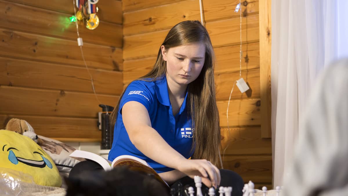 Anastasia Nazarova pelaa shakkia huoneessaan Savitaipaleella kissansa kanssa.