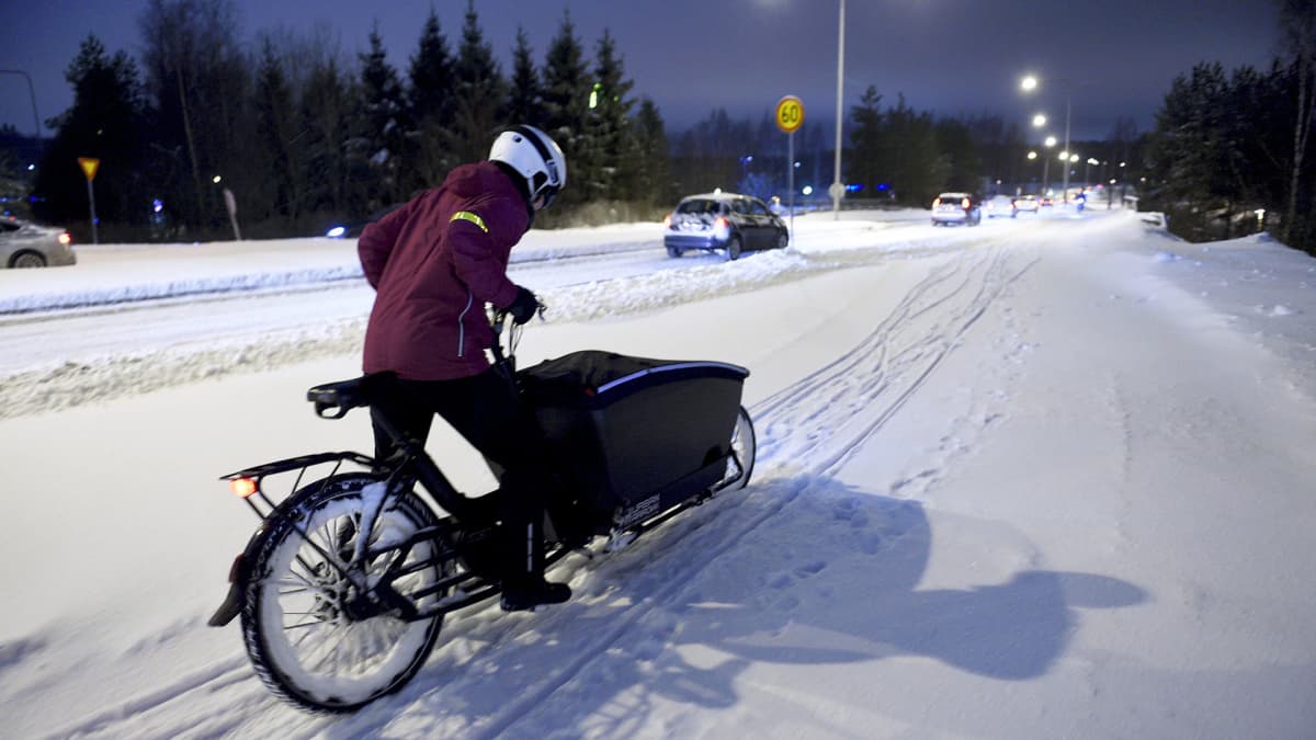 Plkupyöräilijä lumisella tiellä.