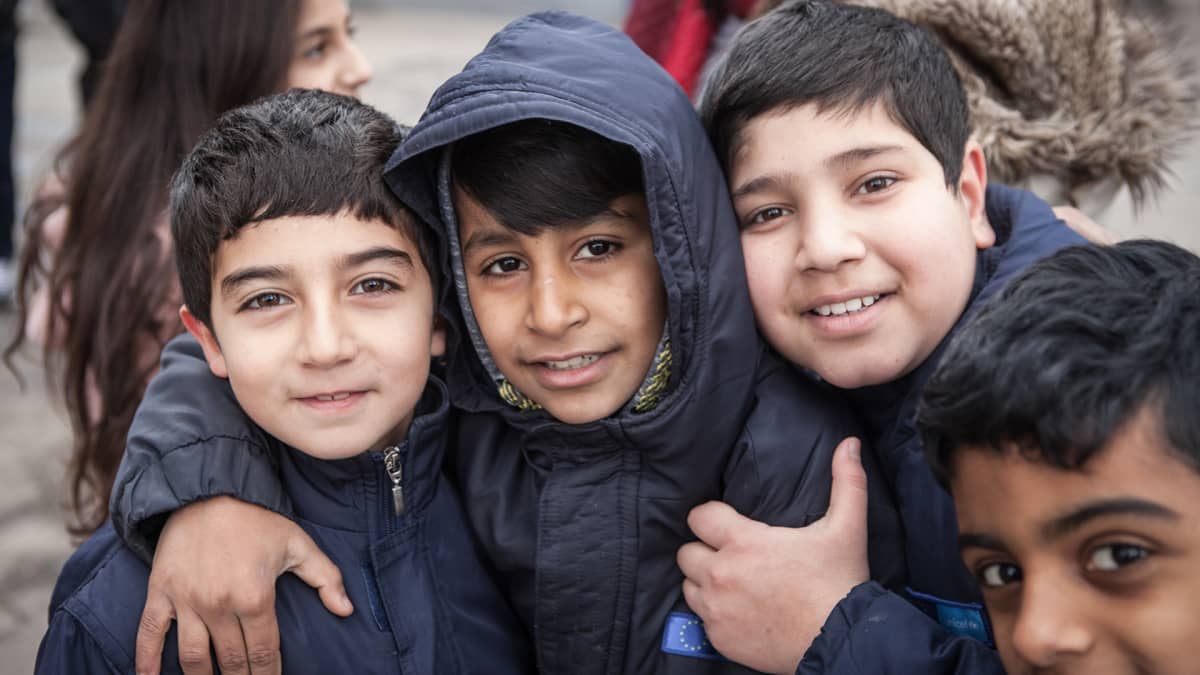 Iranilaiset lapset vastaanottokeskuksen pihalla Sidissä.