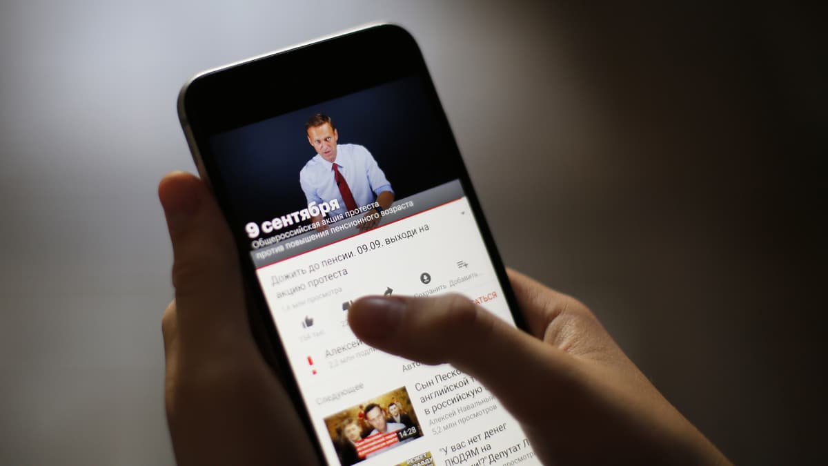 Venäläinen nainen katselle YouTube-videota kännykällä.
