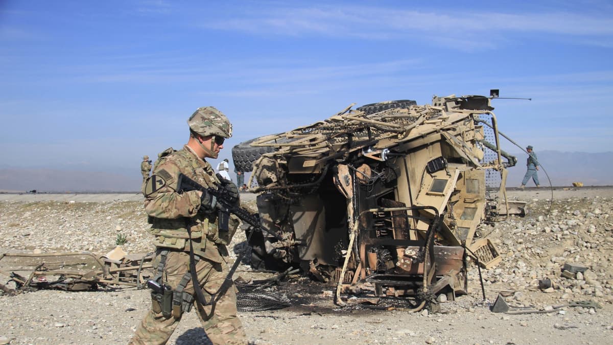Yhdysvaltalainen sotilas tutkii itsemurhaiskun tuhoamaa ajoneuvoa Afganistanissa.