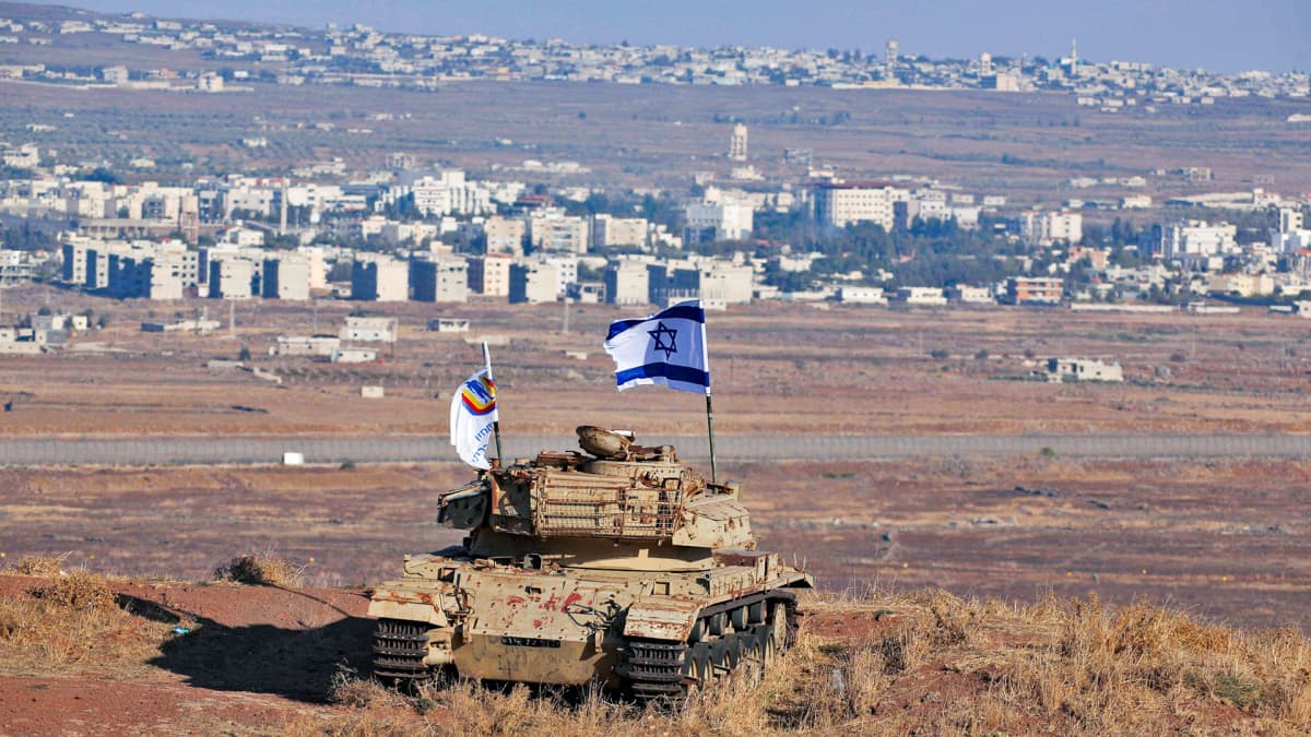 Israelin lippu heiluu vanhassa armeijan tankissa Israelin puolella Golanin kukkuloita.