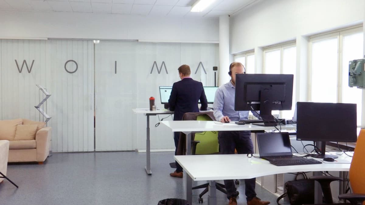 Woima Corporationin työntekijöitä työpisteillään