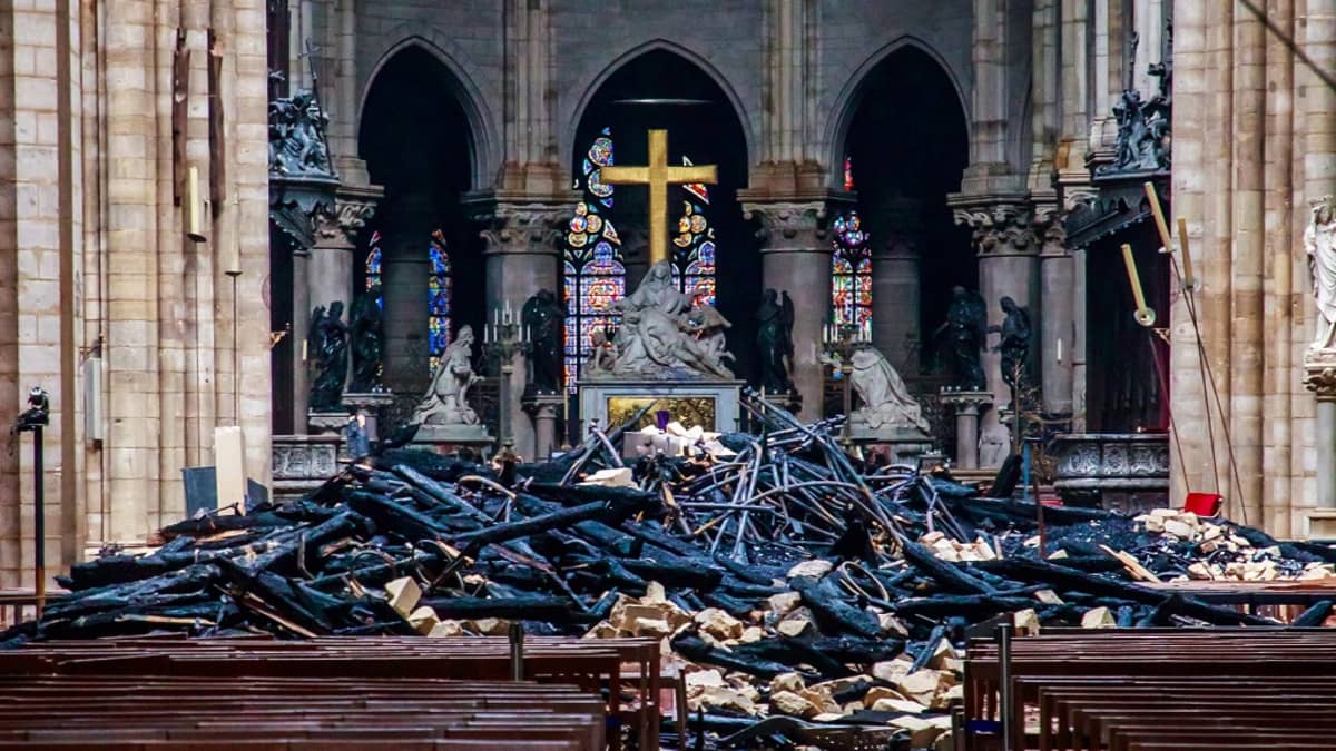 Kuva Notre Damen katedraalin sisältä palon jälkeen. Ristin ja penkkien välissä on palossa syntynyttä rojua. 