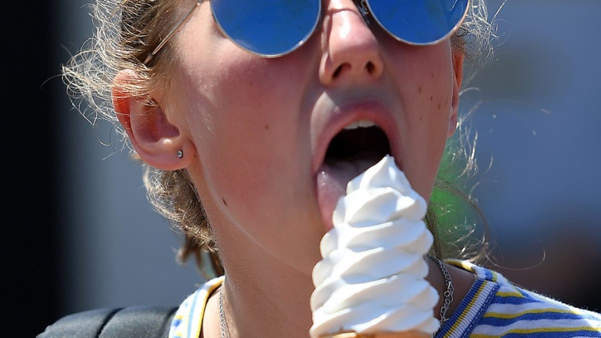 Nuori nainen nuolee jäätelöä. 