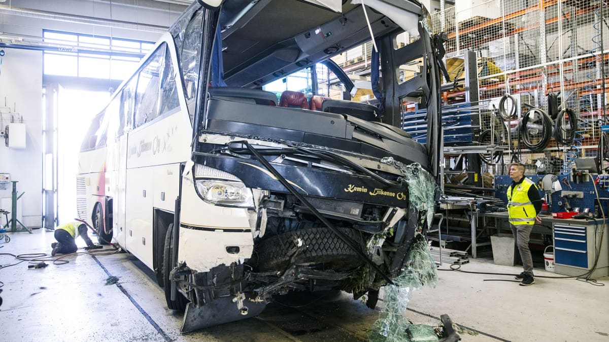 Onnettomuustutkintakeskuksen tutkijat työskentelevät bussivarikolla.