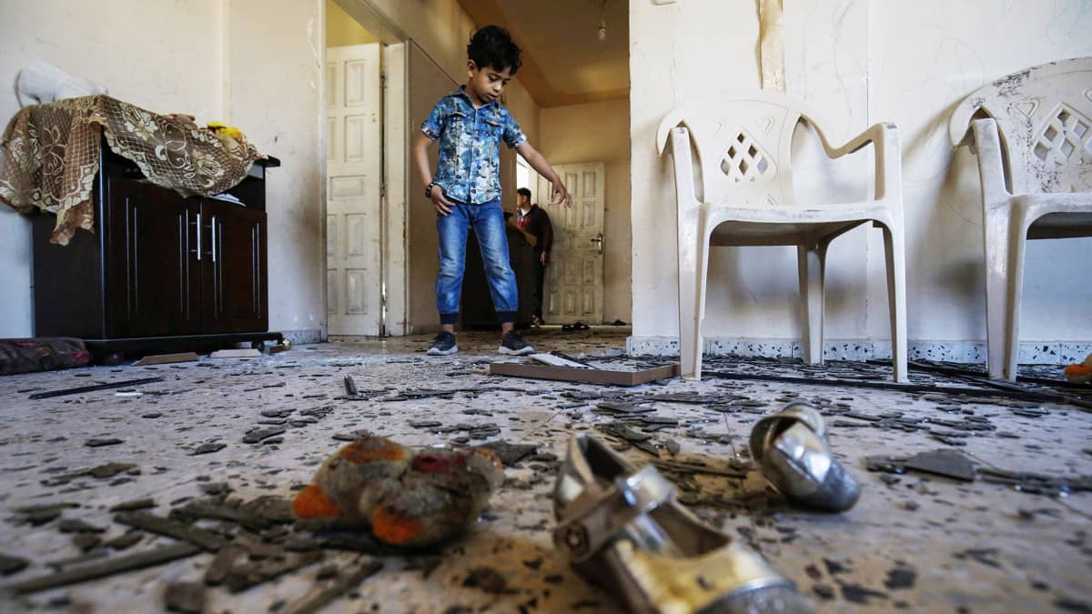 Palestiinalaispoika perheensä vahingoittuneessa asunnossa Israelin ilmaiskun jälkeen Rafahissa sunnuntaina.