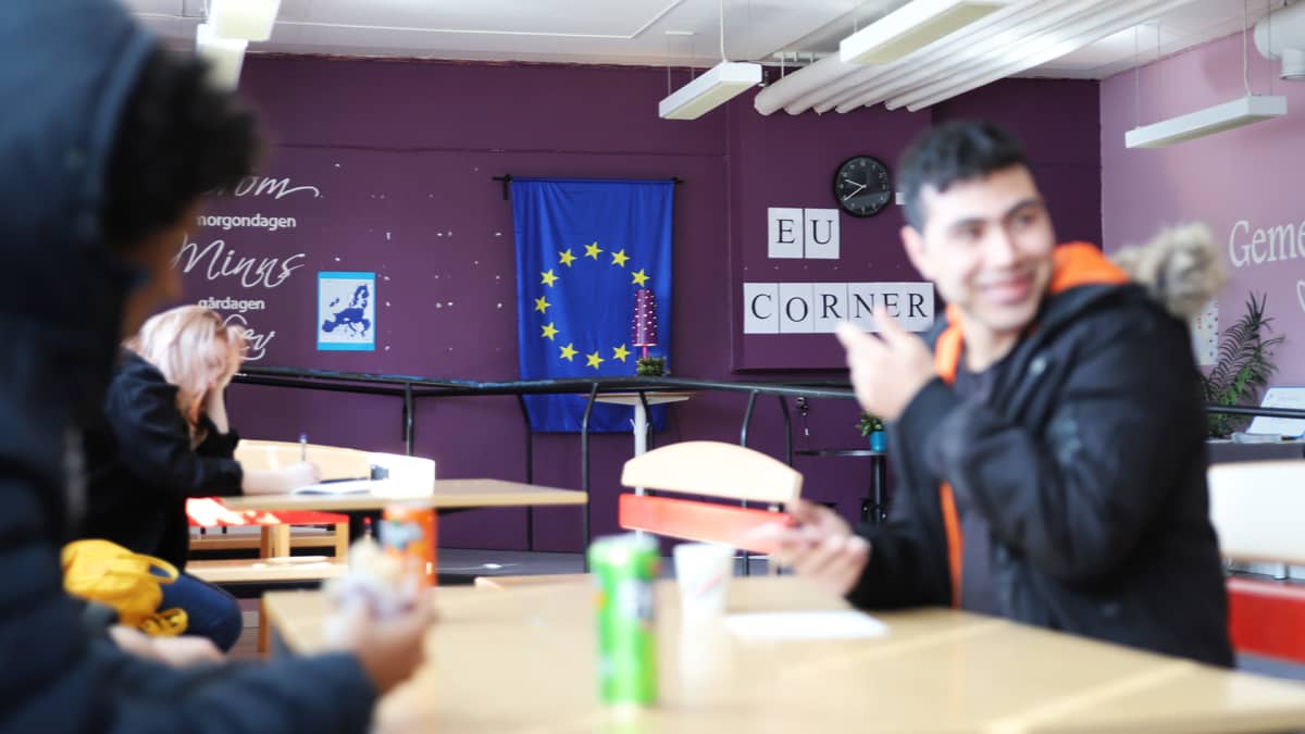 Lukiolaisia Haaparannan Tornedalsskolanin kahvilassa, taustalla EU Corner.