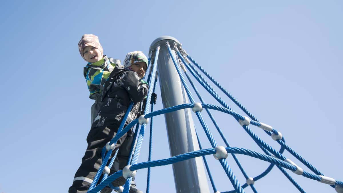 Kasperi Korhonen ja Rahul Fadte kiipeilevät kuopiolaisen leikkipuiston telineessä.