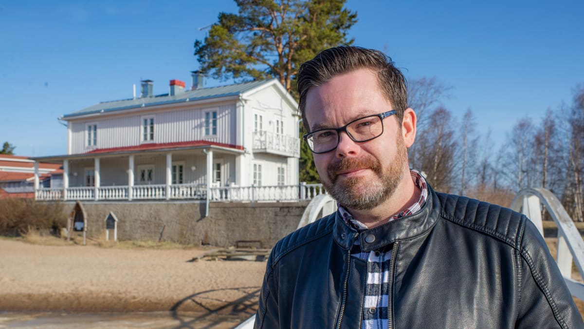 Kuvassa Janne Erkkilä seisoo laiturilla. Taustalla on hääpaikkana toiminut Villa Elba.