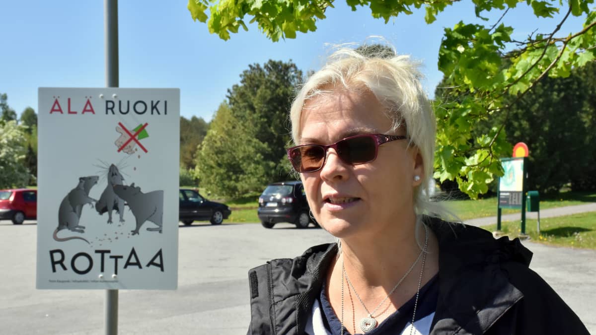 Porin kaupungin terveysinsinööri Heidi Rosenblad Älä ruoki rottaa -kyltin edessä.
