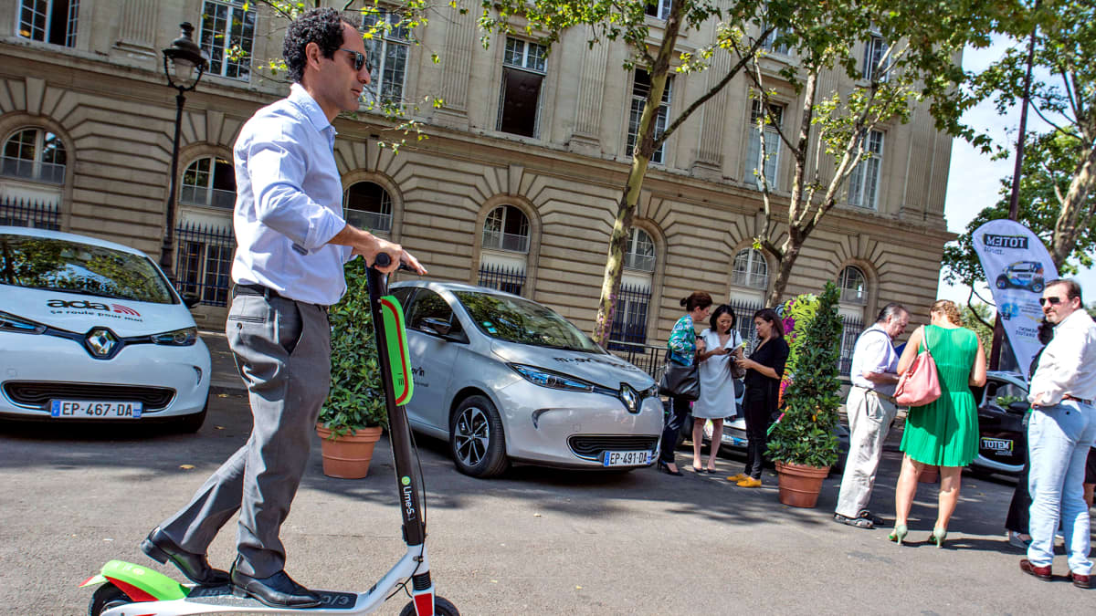 Keski-ikäinen mies liikennöi sähköpotkulaudan avulla Pariisin keskustassa 19. heinäkuuta.