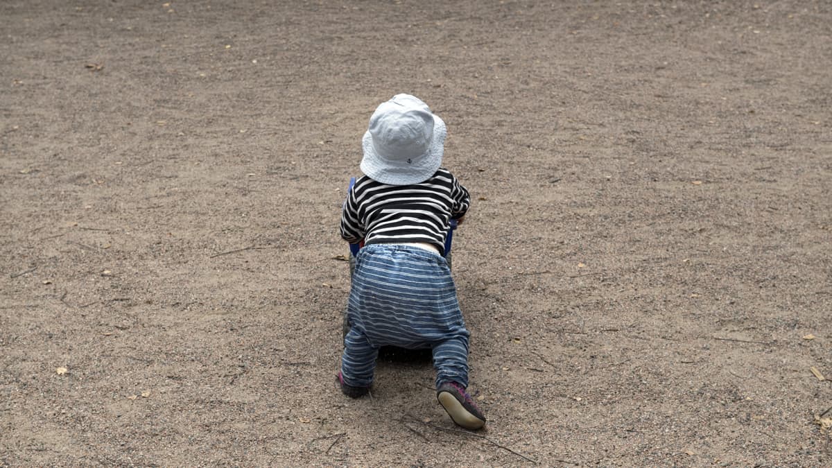 Pieni lapsi leikkii leikkipuistossa.