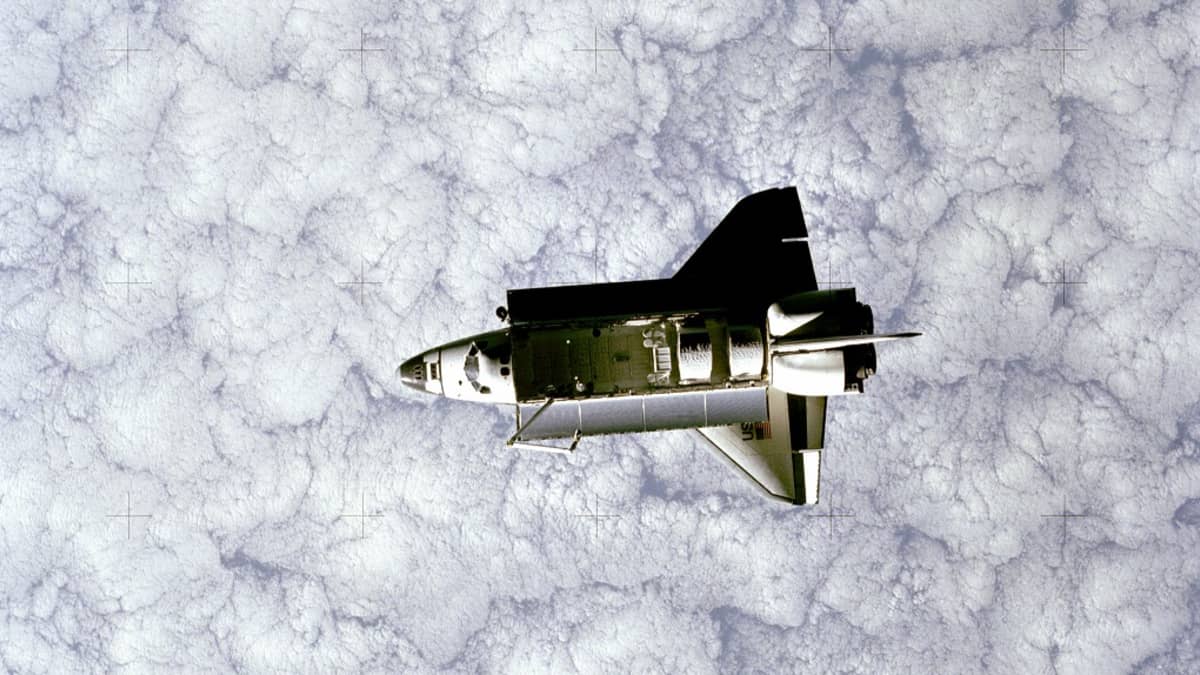 Avaruussukkula Challenger satelliitin kuvaamana . Alla Maan paksu pilviverho. 