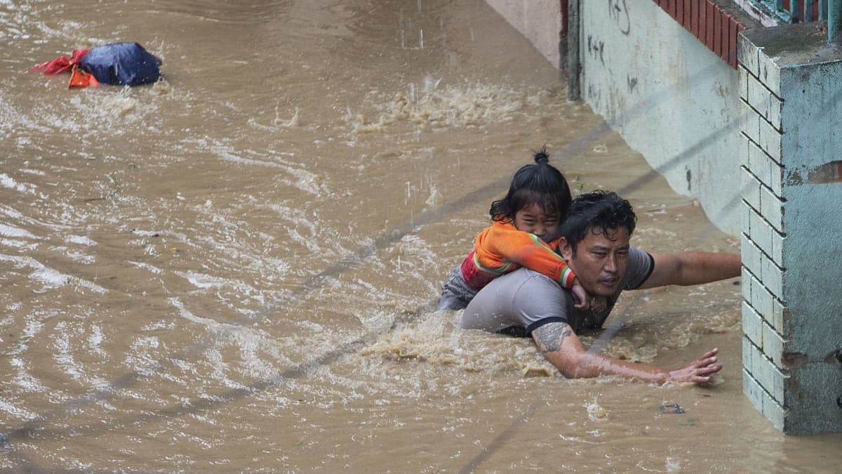 Mies kantoi tytärtään turvaan tulvaveden saartamassa Katmandussa. 