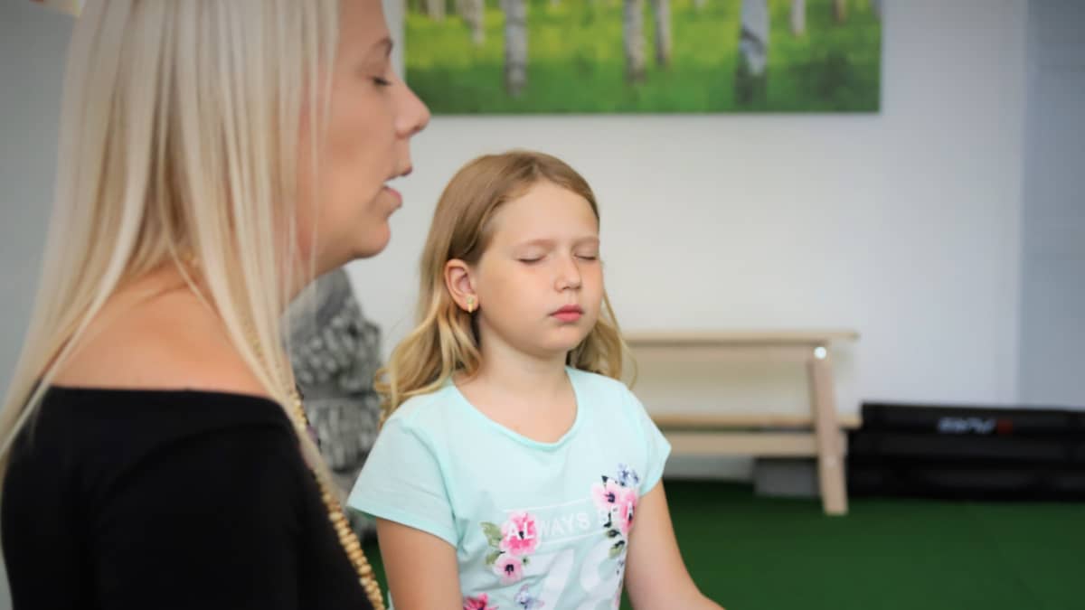 Lapsi toteuttaa mindfulness-harjoituksia yhdessä ohjaajan kanssa