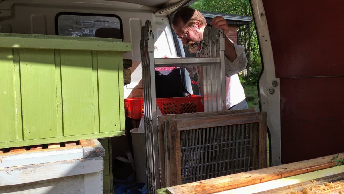 Hannu Luukinen pakkaa pakettiautoaan mehiläisparven kiinniottokeikalle.