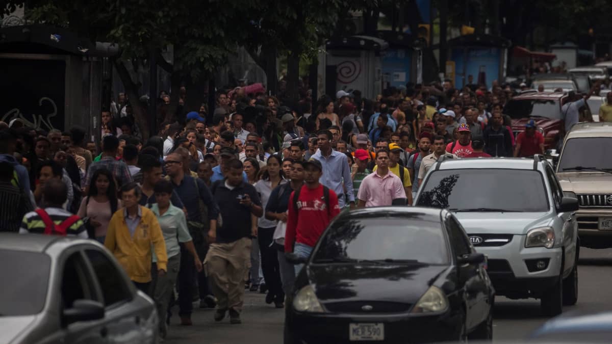 Ihmiset odottivat tai kävelivät kaduilla, sillä metro ei toiminut Caracasissa 22. heinäkuuta. 
