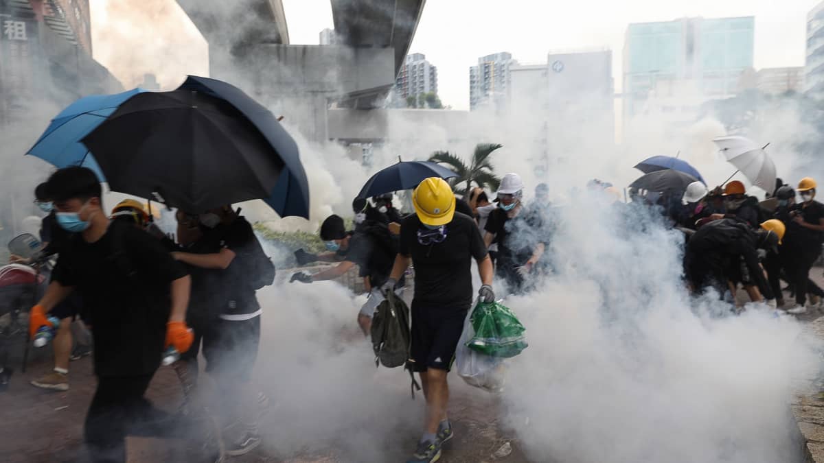 Mielenosoittajat suojautuvat sateenvarjoilla.