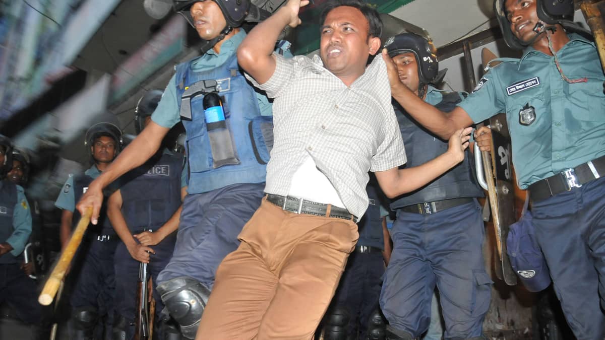 Poliisi pidättä mielenosoittajia Dhakaassa marraskuussa 2013.