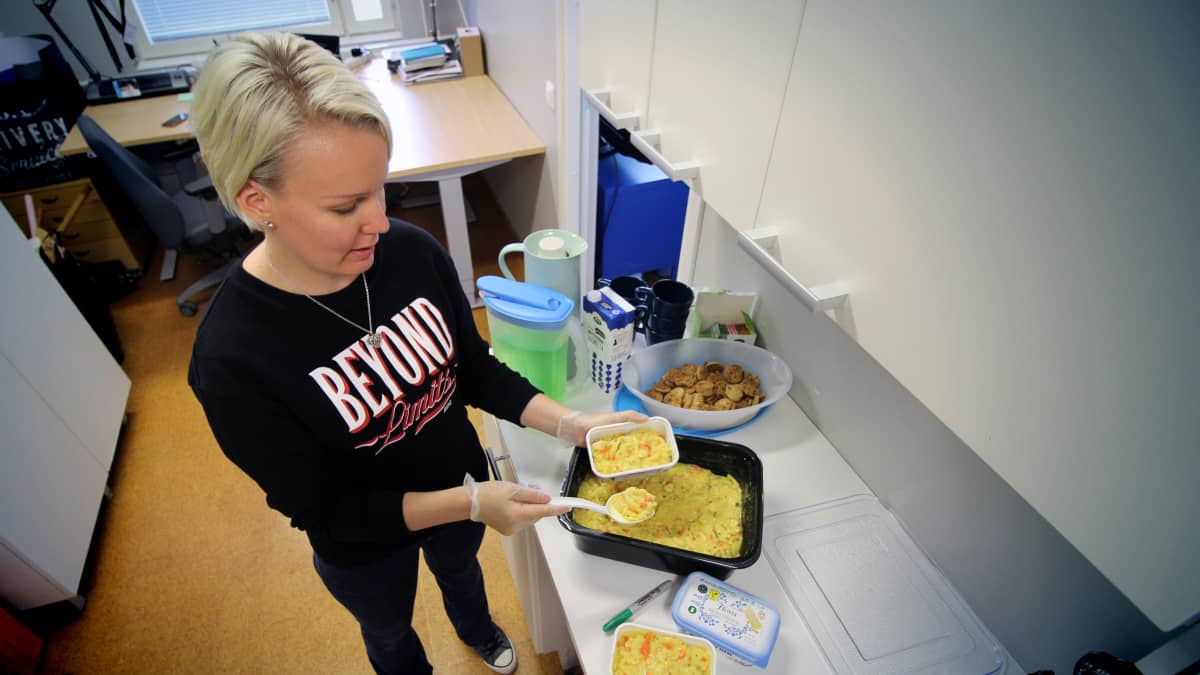 Nuoriso-ohjaaja Sari Paavonsalo siirtää Joroisten yhtenäiskoulun ruokalasta jäänyttä ylijäämäruokaa pienempiin rasioihin.