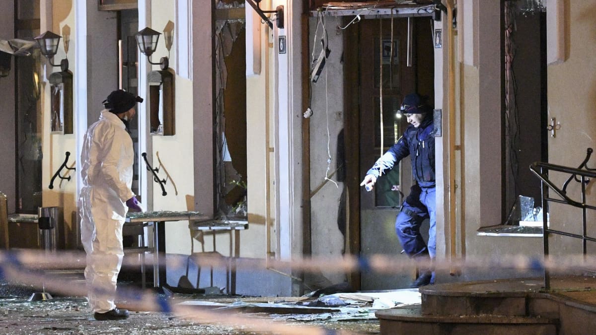 Poliisin tutkijat räjähdyksessä vaurioituneen ravintolan edustalla.